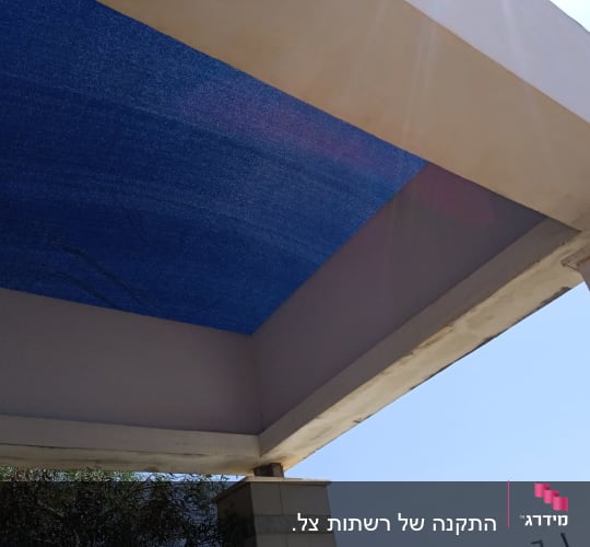 סוכך כחול מתוח על מסגרת מתכתית
